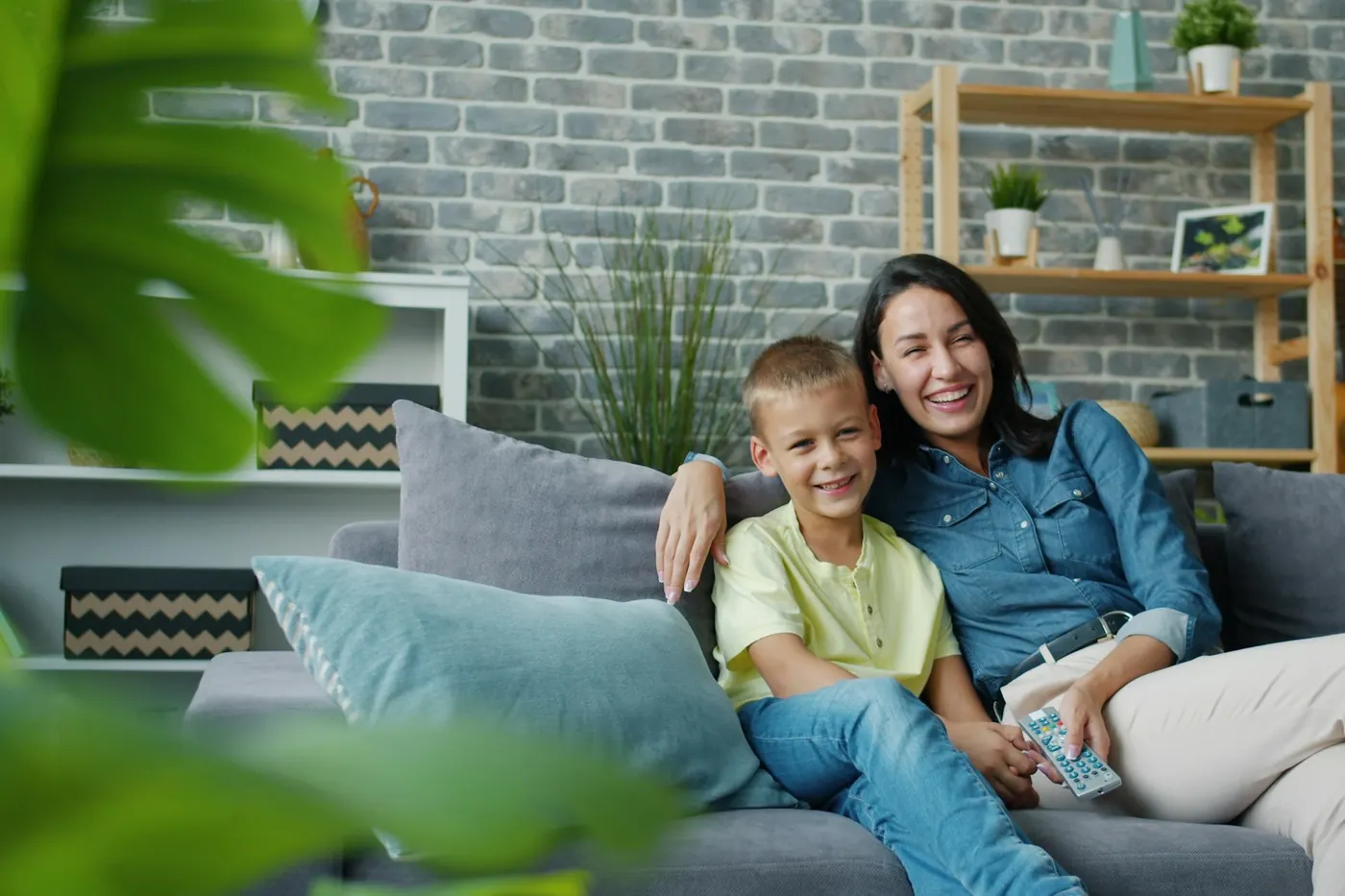 Una madre e il figlio sorridenti sul divano di casa